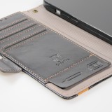 Etui cuir iPhone 16e - Flip Wallet en cuir véritable avec stripe design et compartiment à cartes - Noir